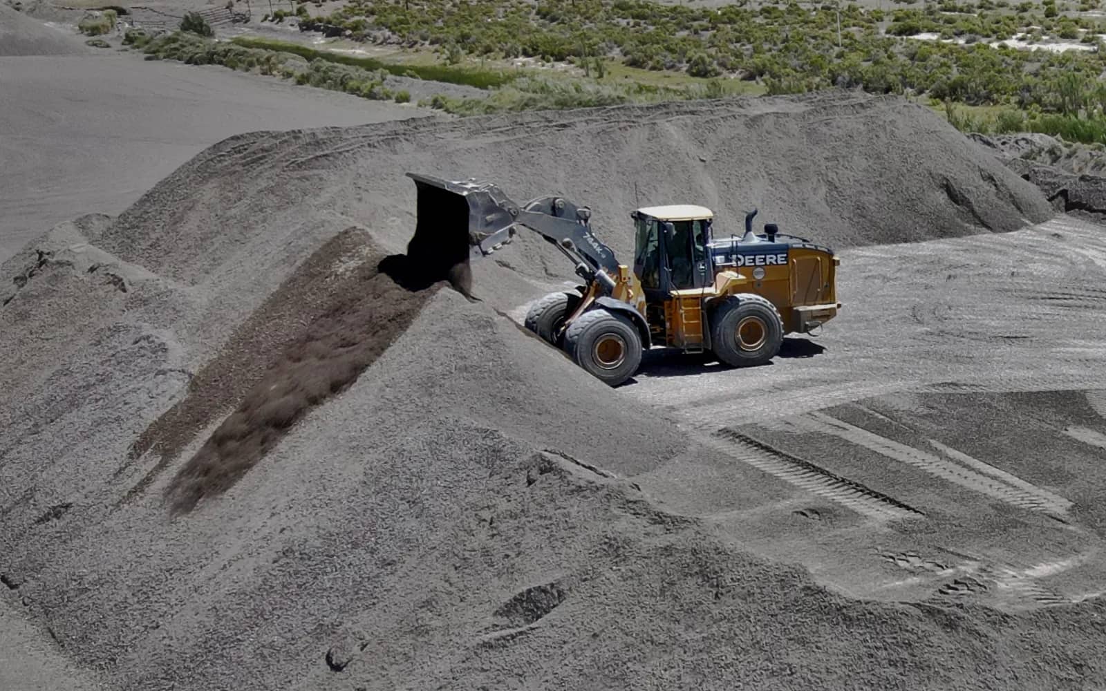 Loader dumping over berm into stockpile